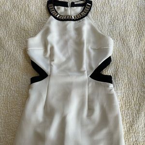 White dress with cut out sides and metal chain neckline.